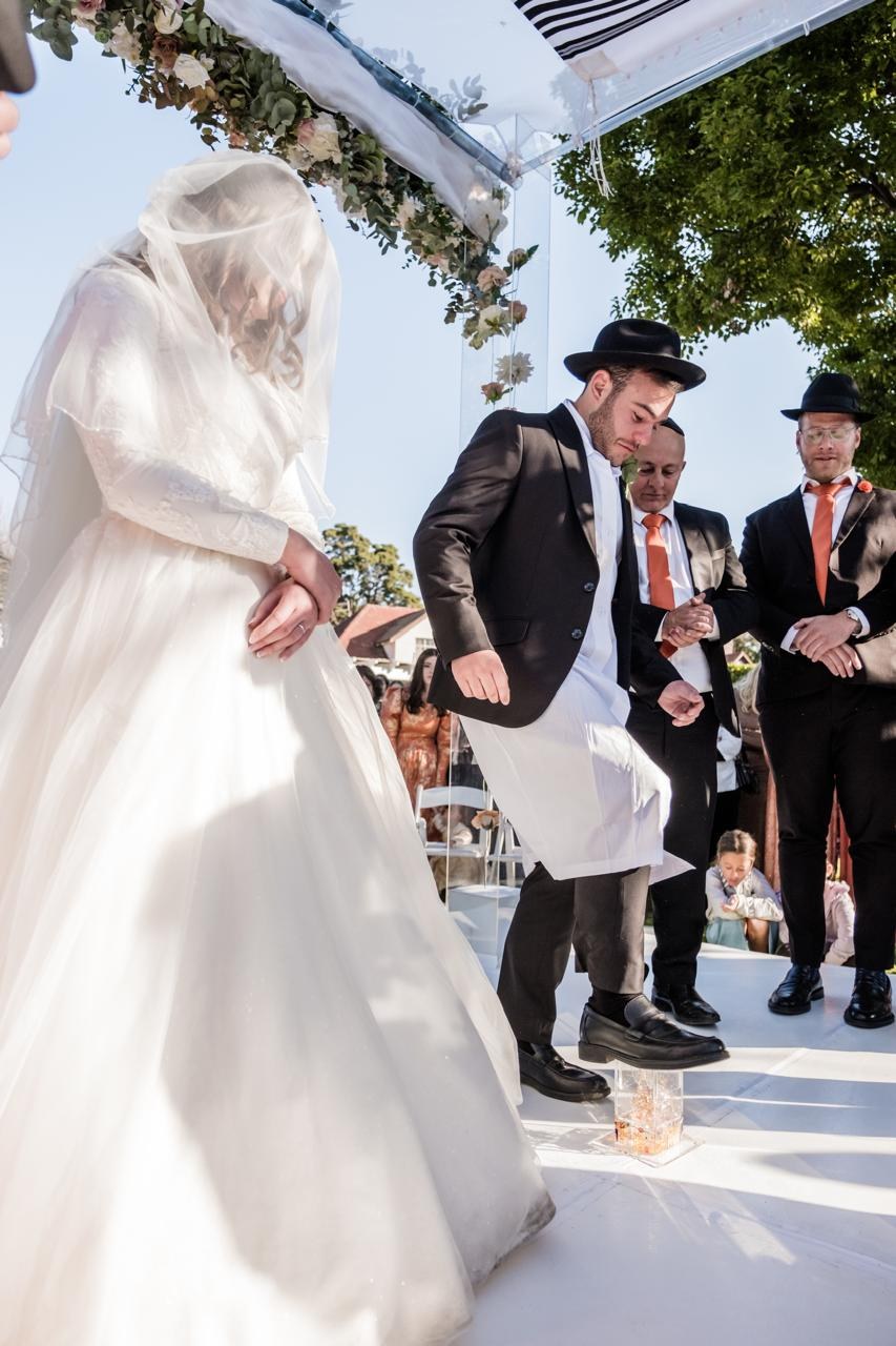 A chassidic groom breaks the glass under the chuppah